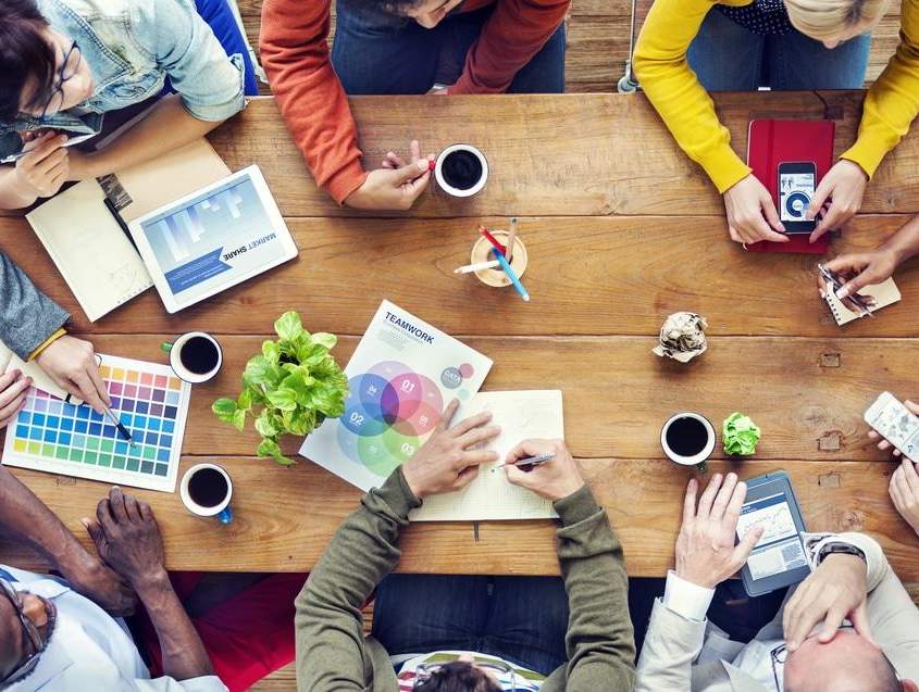 Meeting im Filmstudio Berlin Ein paar Kreative sitzen zur Besprechung an einem alten Holztisch in einem Filmstudio Berlin