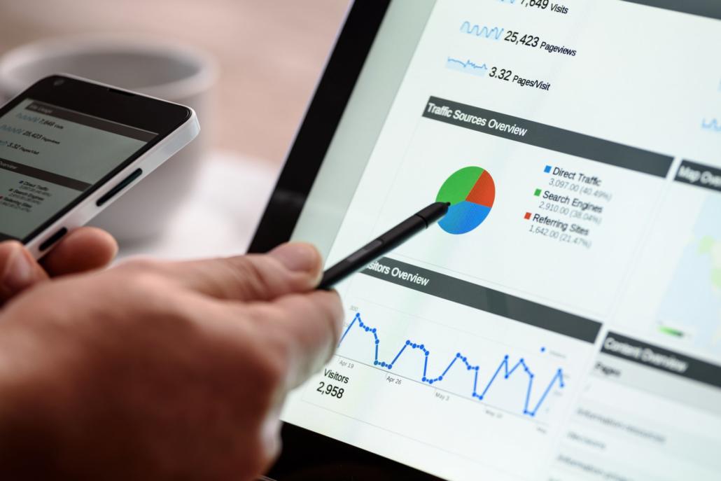 Webdesigner analysiert Daten beim Kunden Webdesigner zeigt auf Analytics-Statistik auf Tablet mit Smartphone in der Hand