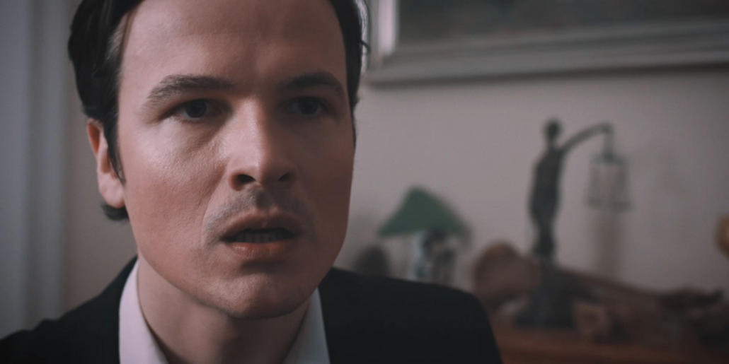 Der Schauspieler Frederic Stromenger ist in einer Kurzfilmproduktion in einer Großaufnahme vor unscharfem Hintergrund zu sehen, wie er besorgt rechts an der Kamera vorbei guckt.