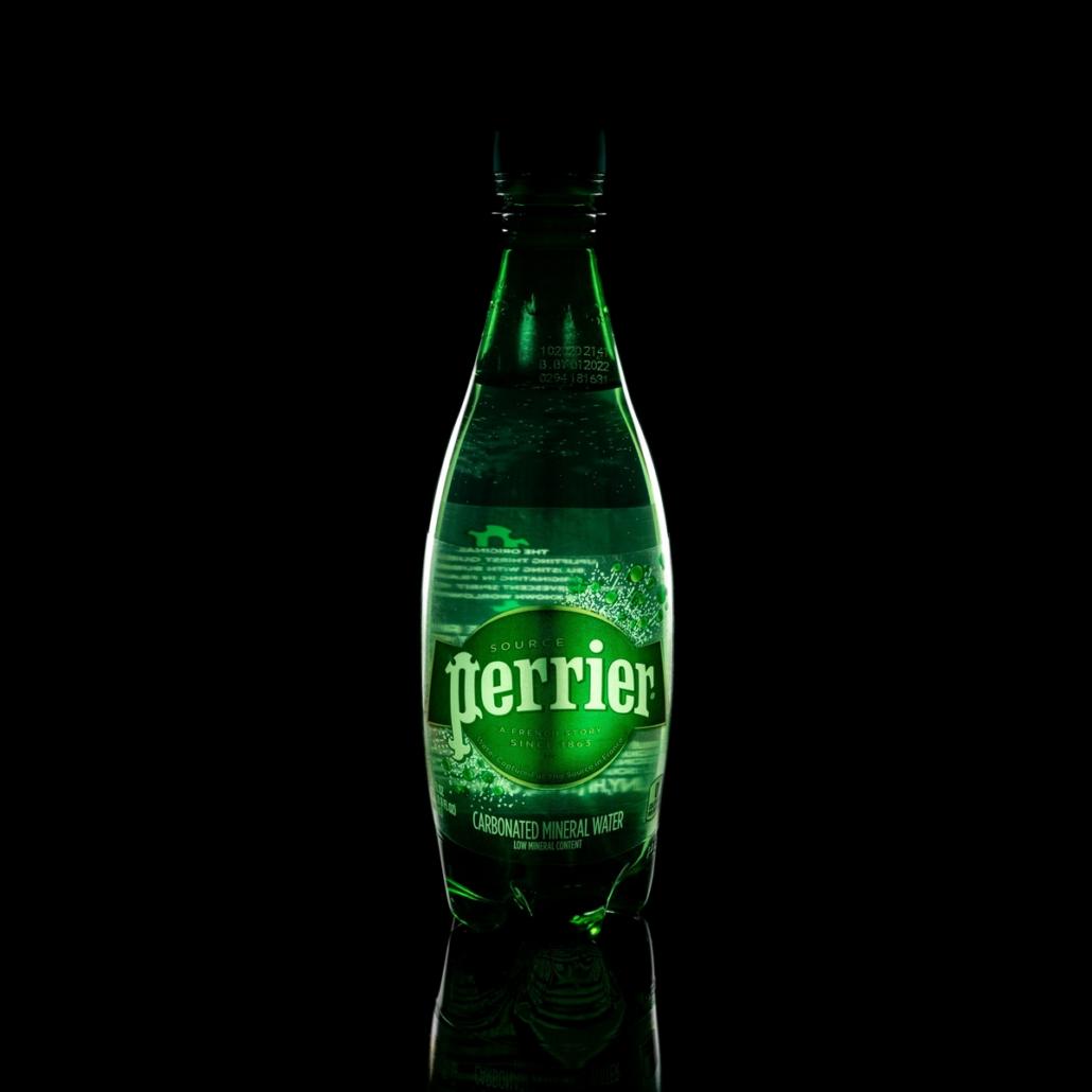 Für ein Mineralwasser der Firma Perrier ein Produktvideo erstellen lassen Für ein Mineralwasser ein Produktvideo erstellen lassen. Beispielhaft dafür sehen wir auf diesem Bild eine Flasche Mineralwasser der Firma Perrier mit grünem Etikett frontal vor schwarzem Hintergrund. Die Szene ist Low-Key ausgeleuchtet und in der Flasche reflektiert sich das Licht auf eindrucksvolle Art und Weise.