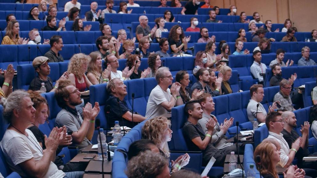 Als beauftragter Livestream-Dienstleister Berlin waren wir im Auditorium vom Langebeck-Virchow-Haus, und fotografierten die runden blau-gepolsterten Sitzreihen mit applaudierenden Menschen von der Seite.