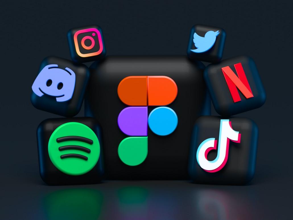 Dargestellt sind die Icons mehrerer Social Media Plattformen wie Tik Tok, Twitter, Netflix und Instagram, welche vor dunkelgrauem Hintergrund als 3D-Grafiken symmetrisch angeordnet sind.